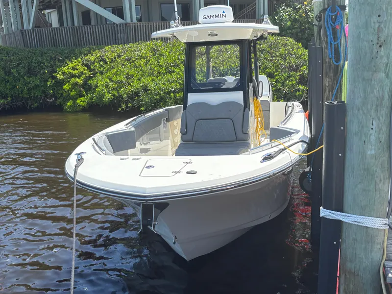 Slide: The Image of 2023 Stingray 273 CC boat docked, featuring Garmin equipment, in a serene waterfront setting. - 4