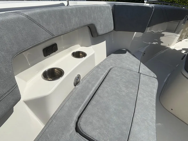 Slide: The Image of 2023 Stingray 273 CC boat interior with gray seating and cup holders. - 9