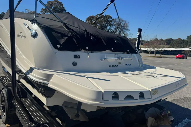 Slide: The Image of 2008 Sea Ray 260 Sundeck boat with black cover in a parking lot. - 4