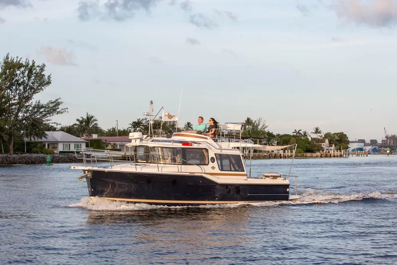 The Image of 2026 Ranger Tugs R-29CB cruising on a scenic waterway with passengers onboard. - 1
