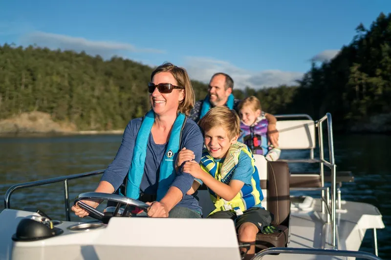 Slide: The Image of Family enjoying a boat ride on a 2026 Ranger Tugs R-29CB in scenic waters. - 27