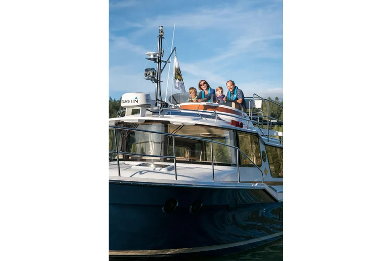 Slide: The Image of 2026 Ranger Tugs R-29CB boat with people enjoying a sunny day on deck. - 29