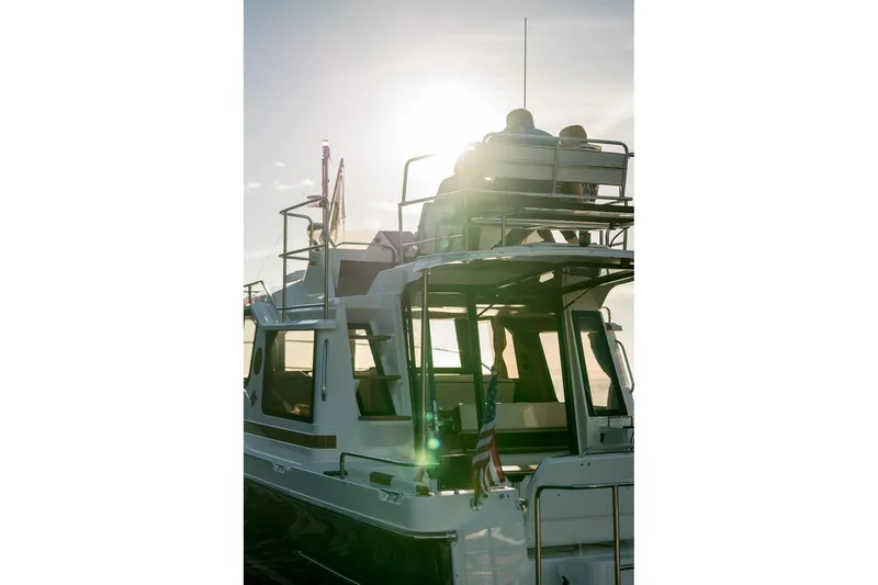 Slide: The Image of 2026 Ranger Tugs R-29CB boat with people enjoying sunset on upper deck. - 32