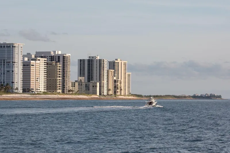 Slide: The Image of 2026 Ranger Tugs R-29CB cruising near coastal city skyline. - 42