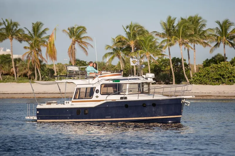 Slide: The Image of 2026 Ranger Tugs R-29CB cruising near a tropical beach with palm trees. - 46