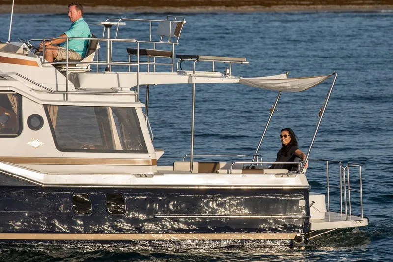 Slide: The Image of 2026 Ranger Tugs R-29CB cruising on water with two passengers onboard. - 5