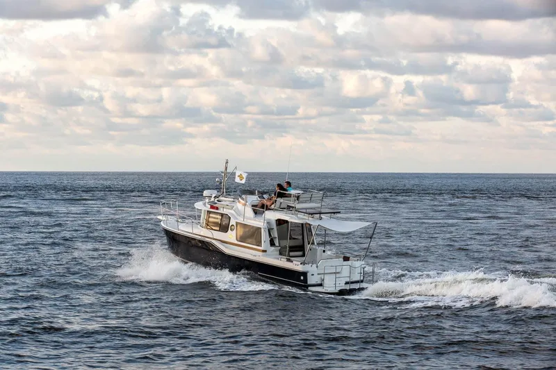 Slide: The Image of 2026 Ranger Tugs R-29CB cruising on open water under cloudy skies. - 6