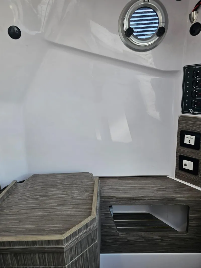 Slide: The Image of Interior cabin of 2025 Ranieri CAYMAN 27.0 SPORT TOURING boat with porthole and control panel. - 15