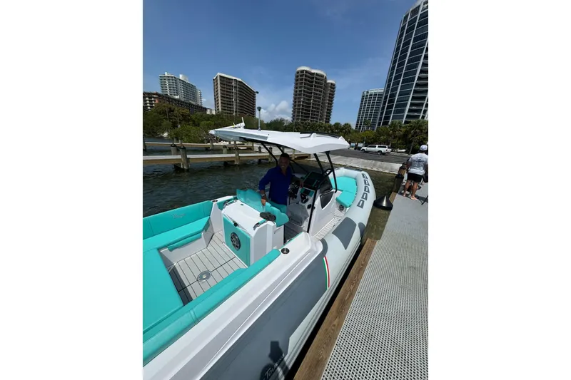 Slide: The Image of 2026 Ranieri CAYMAN 27.0 SPORT TOURING boat docked near modern high-rise buildings. - 27