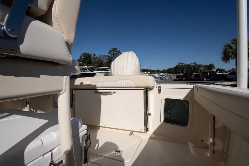 Slide: The Image of 2026 Scout 220 XSF boat interior with seating and storage, under clear blue sky. - 10