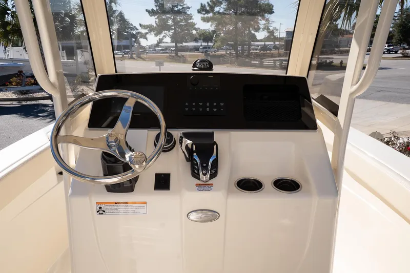 Slide: The Image of 2026 Scout 220 XSF boat helm with steering wheel and control panel. - 11