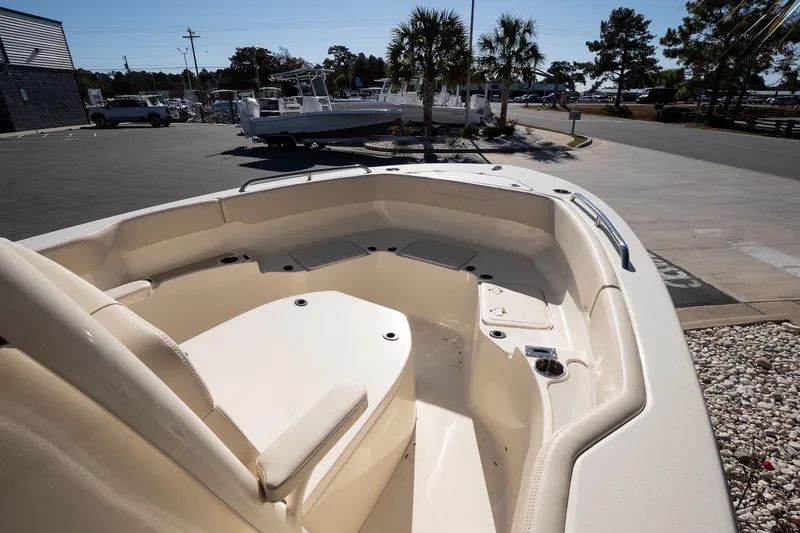 Slide: The Image of 2026 Scout 220 XSF boat interior with seating, docked outdoors under clear skies. - 15