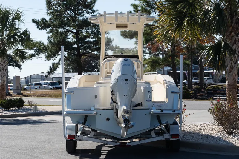 Slide: The Image of 2026 Scout 220 XSF boat on trailer, parked outdoors near palm trees. - 5