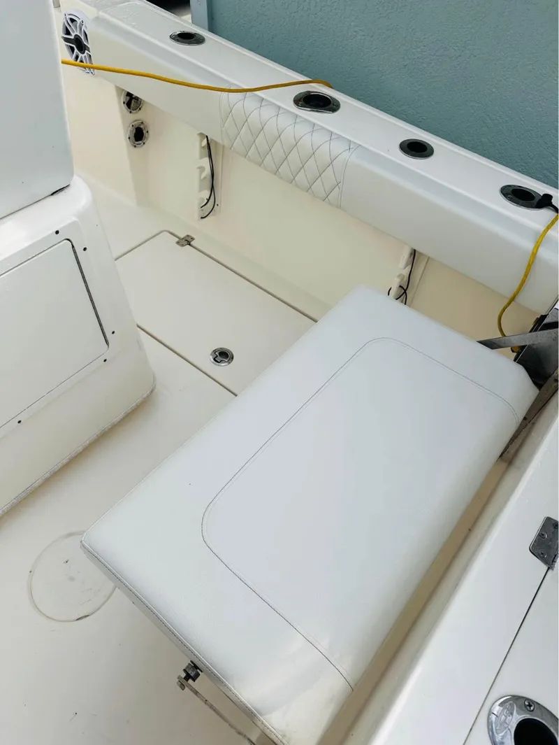 Slide: The Image of 2019 Cobia 237 Center Console boat interior with white seating and rod holders. - 10