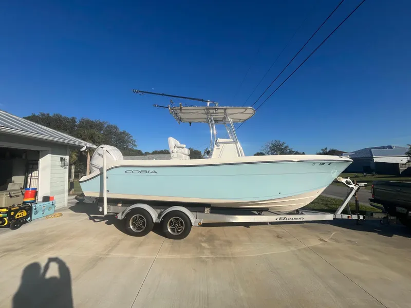 Slide: The Image of 2019 Cobia 237 Center Console boat on trailer in driveway. - 11
