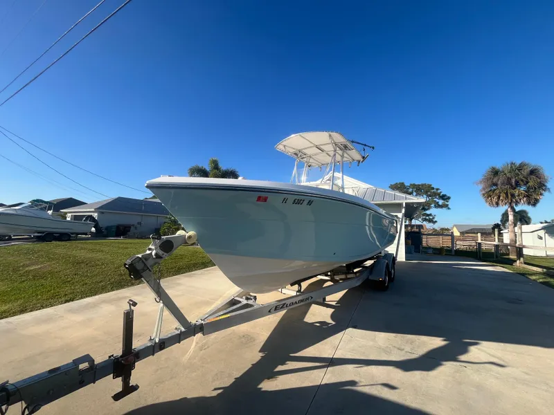 Slide: The Image of 2019 Cobia 237 Center Console boat on trailer, parked in sunny driveway. - 14