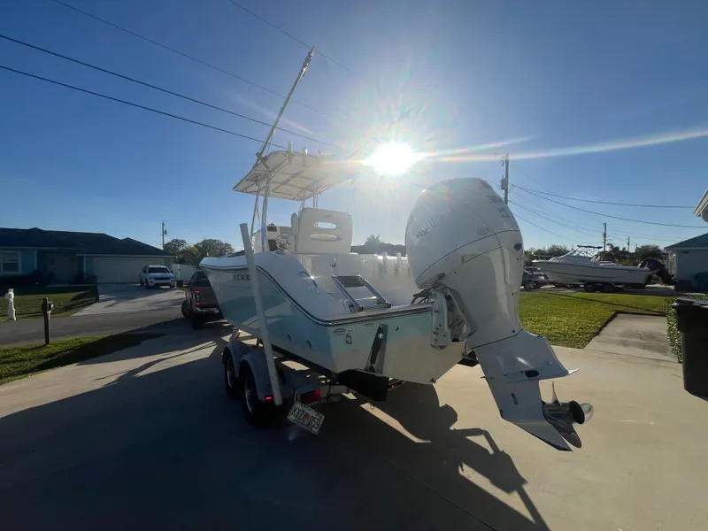 Slide: The Image of 2019 Cobia 237 Center Console boat on trailer in sunny driveway. - 15