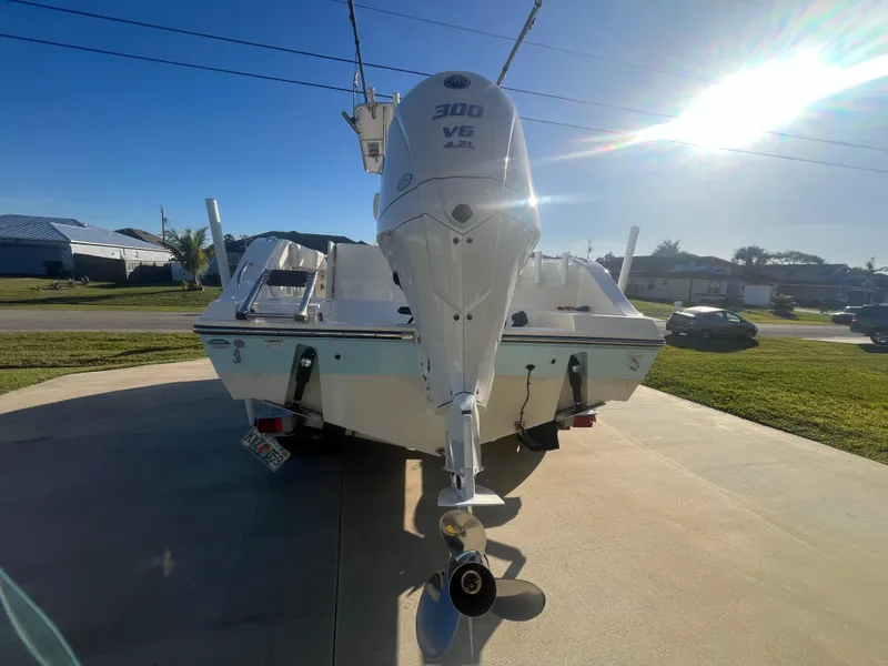 Slide: The Image of 2019 Cobia 237 Center Console boat with powerful 300 V6 engine, parked on driveway. - 17