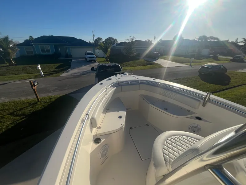 Slide: The Image of 2019 Cobia 237 Center Console boat parked in a sunny residential neighborhood. - 29