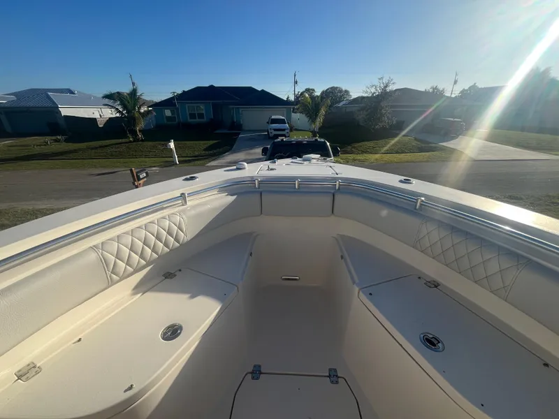 Slide: The Image of 2019 Cobia 237 Center Console boat, spacious deck, residential background, sunny day. - 30