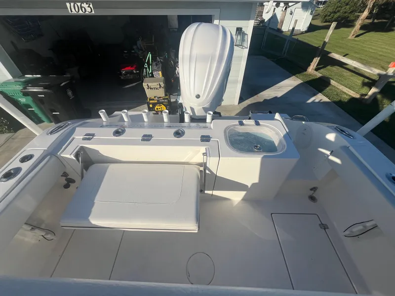 Slide: The Image of 2019 Cobia 237 Center Console boat with seating and storage, parked in driveway. - 41