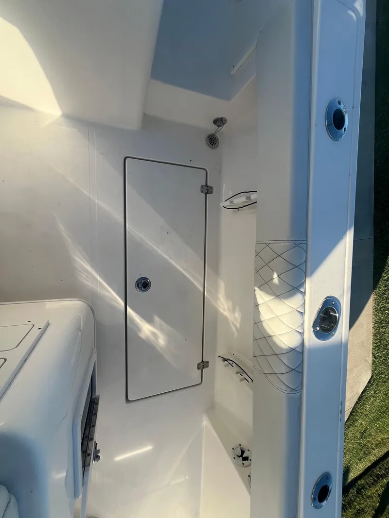 Slide: The Image of 2019 Cobia 237 Center Console boat interior, featuring storage compartment and clean design. - 42