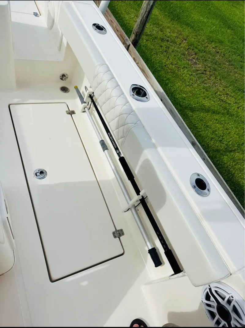 Slide: The Image of 2019 Cobia 237 Center Console boat interior with rod holders and storage compartment. - 7