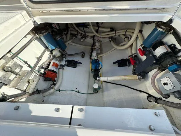 Slide: The Image of 2015 Invincible 39 Open Fisherman engine compartment with visible hoses and components. - 33