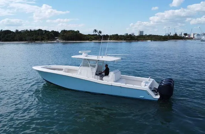 Slide: The Image of 2015 Invincible 39 Open Fisherman boat on calm water, clear sky background. - 4