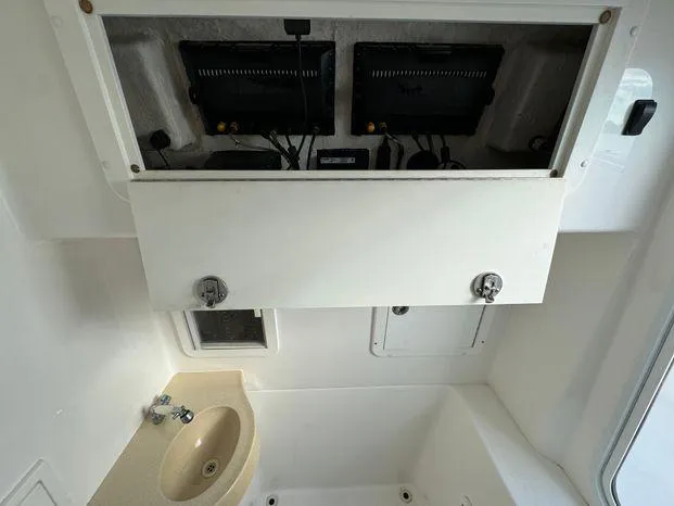 Slide: The Image of 2015 Invincible 39 Open Fisherman interior with sink and storage compartments. - 40