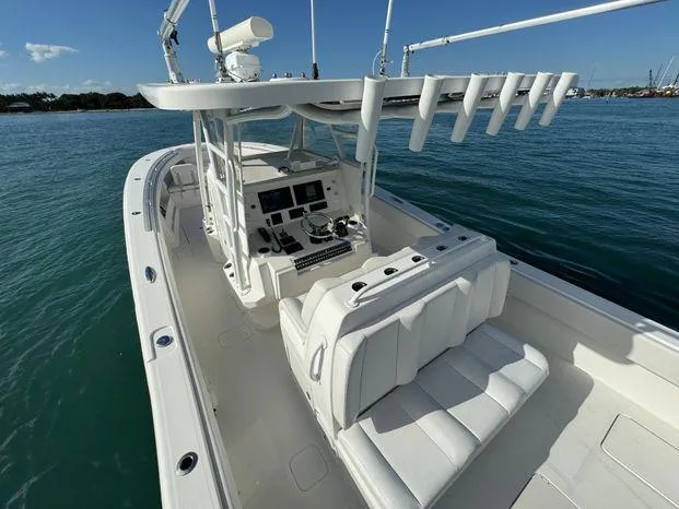 Slide: The Image of 2015 Invincible 39 Open Fisherman boat on calm water, featuring spacious seating and advanced controls. - 7