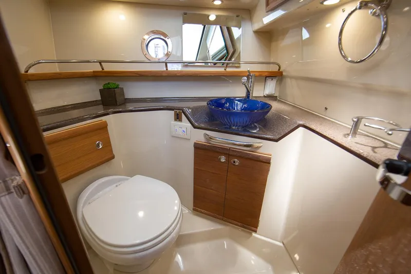 Slide: The Image of Luxurious bathroom in 2026 Ranger Tugs R-29S with modern fixtures and blue glass sink. - 12