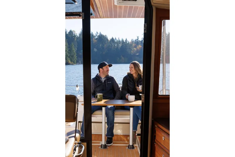 Slide: The Image of Couple enjoying coffee on 2026 Ranger Tugs R-29S boat, scenic lake view. - 23