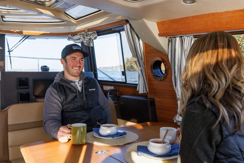 Slide: The Image of Couple enjoying coffee inside 2026 Ranger Tugs R-29S boat cabin. - 25