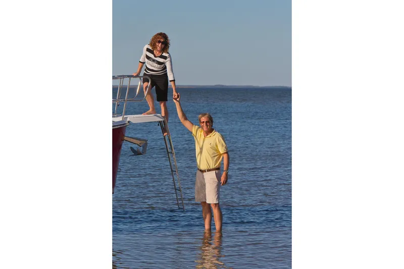 Slide: The Image of Couple enjoying a day on the 2026 Ranger Tugs R-29S boat by the water. - 26