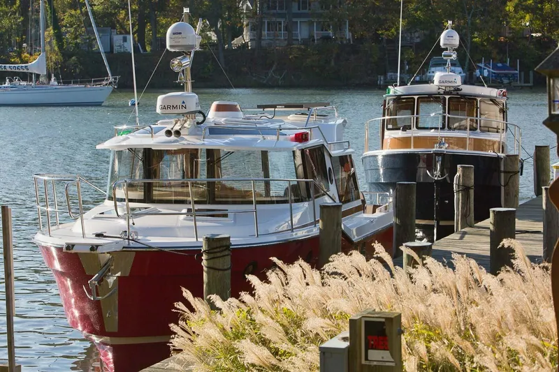 Slide: The Image of 2026 Ranger Tugs R-29S docked by a serene waterfront with lush greenery. - 28