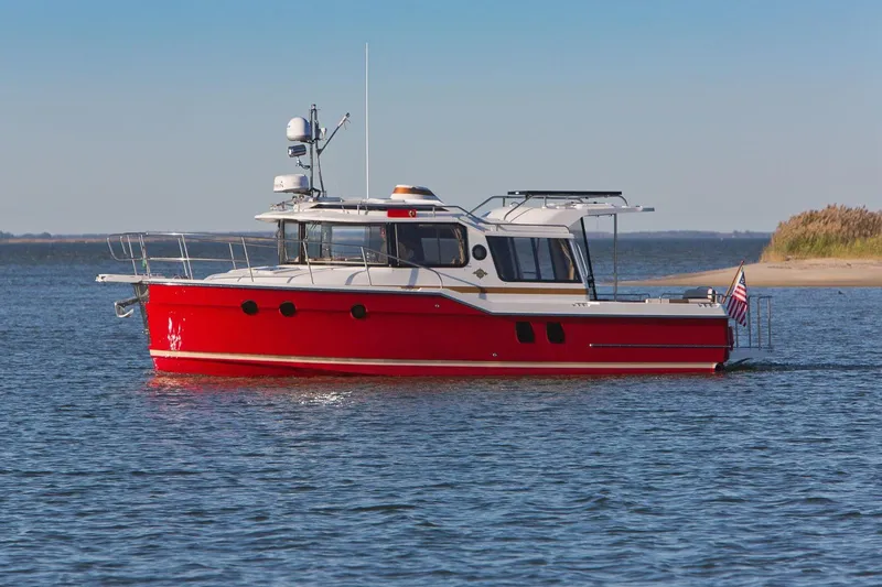 Slide: The Image of 2026 Ranger Tugs R-29S boat in calm waters, featuring a vibrant red hull. - 3