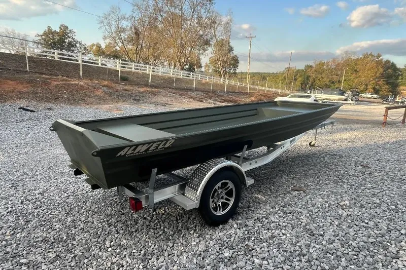 The Image of 2026 Alweld 1648 Marsh Jon boat on trailer, parked on gravel lot. - 1