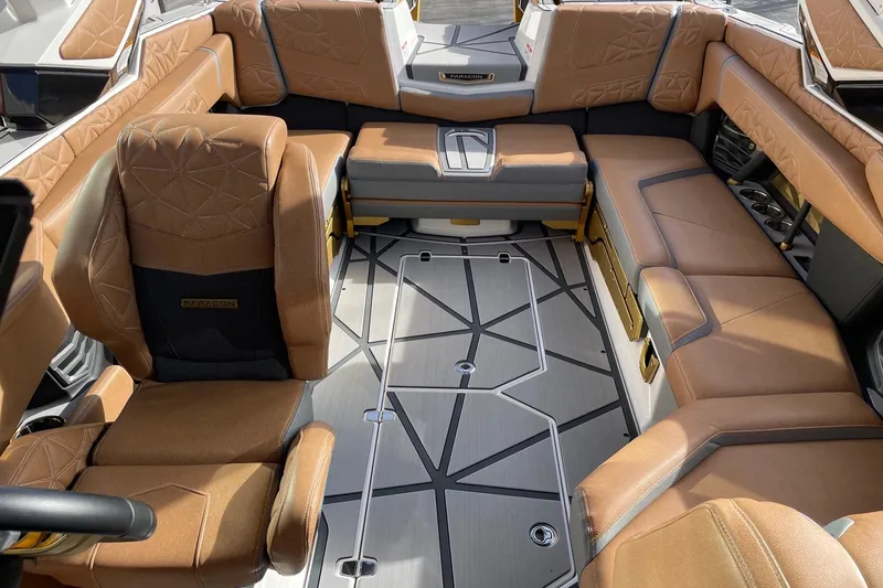 Slide: The Image of 2024 Nautique Super Air Nautique G23 Paragon interior with luxurious brown seating and modern design. - 12