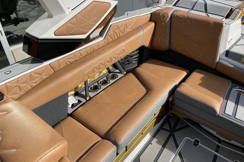Slide: The Image of 2024 Nautique Super Air Nautique G23 Paragon interior with luxurious tan seating and cup holders. - 7