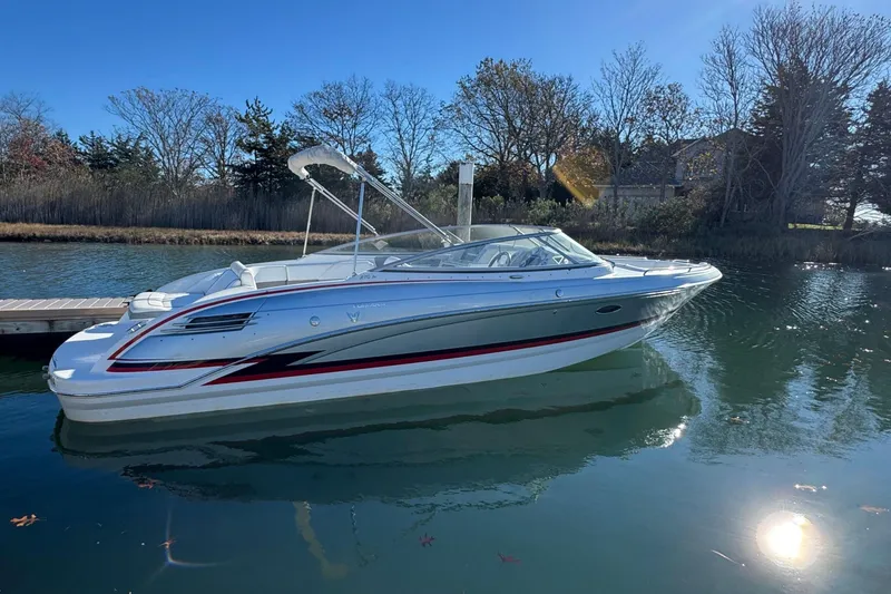 The Image of 2012 Formula 270 Bowrider boat docked on a calm lake under clear blue sky. - 0