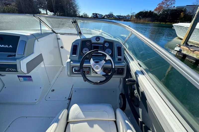 Slide: The Image of 2012 Formula 270 Bowrider boat cockpit with steering wheel and dashboard controls. - 10