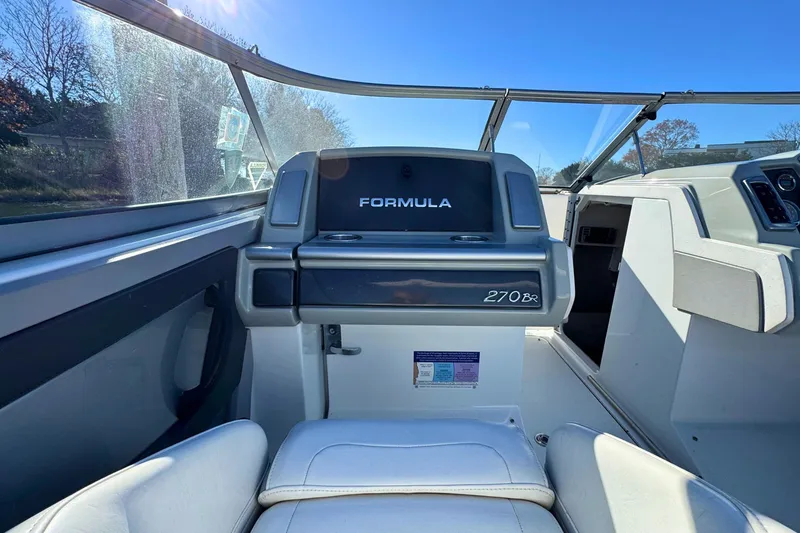 Slide: The Image of 2012 Formula 270 Bowrider interior with seating and dashboard under clear blue sky. - 12