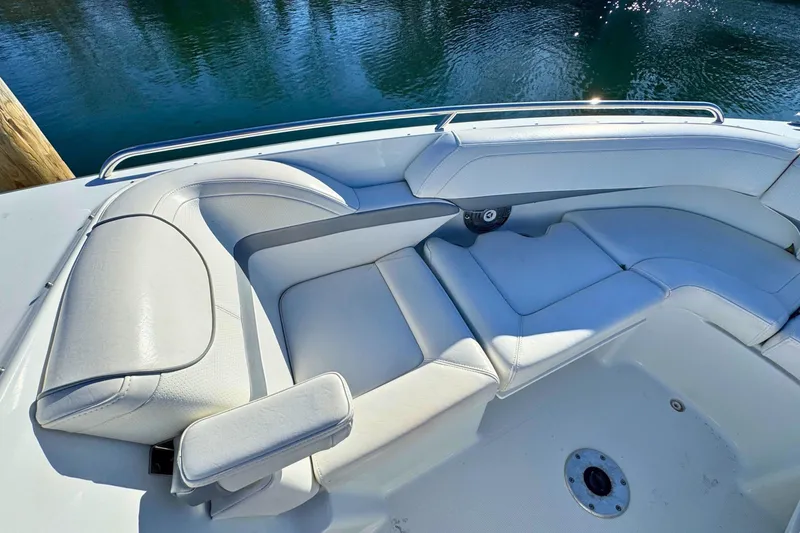 Slide: The Image of 2012 Formula 270 Bowrider boat interior with white cushioned seating by the water. - 17