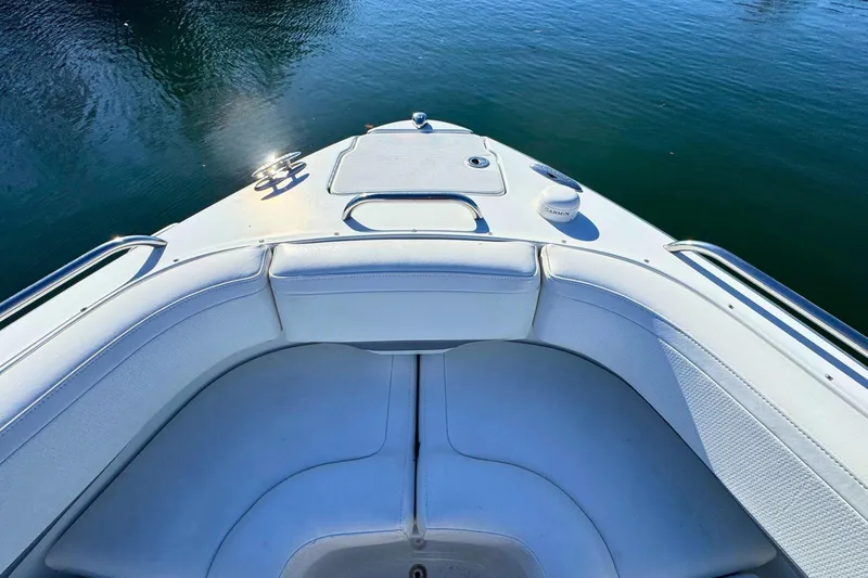 Slide: The Image of 2012 Formula 270 Bowrider boat interior with white seating on calm water. - 19