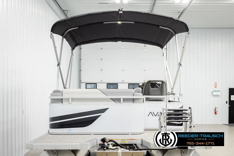 Slide: The Image of 2026 Avalon VEN CR pontoon boat in showroom with canopy and sleek design. - 7