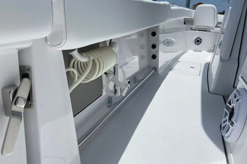 Slide: The Image of 2026 Sportsman Open 322 Center Console boat interior with coiled hose and speakers. - 17
