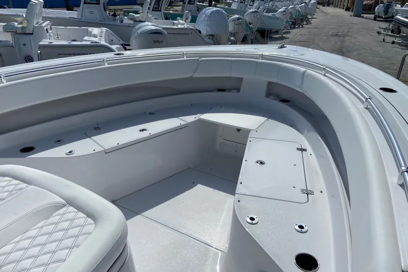 Slide: The Image of 2026 Sportsman Open 322 Center Console boat interior with cushioned seating and storage compartments. - 27