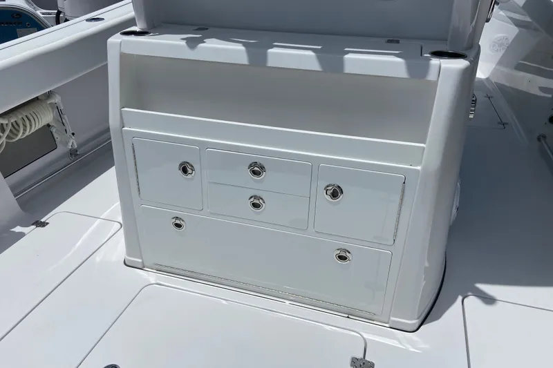 Slide: The Image of 2026 Sportsman Open 322 Center Console storage compartment with multiple drawers on deck. - 13