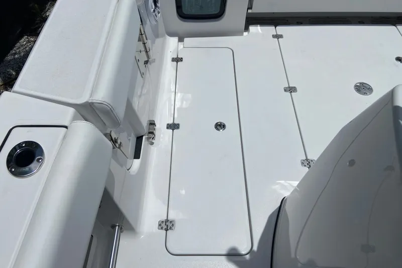 Slide: The Image of The image shows the deck of a 2026 Sportsman Open 322 Center Console boat with white upholstery and storage compartments. - 7